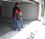 Applicator grinding garage floor.