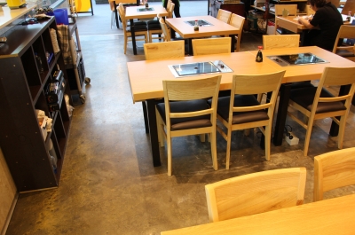 A photo looking from the back of the restaurant, showing the metallic epoxy floor stretching past the seating area and up to the mall entrance.