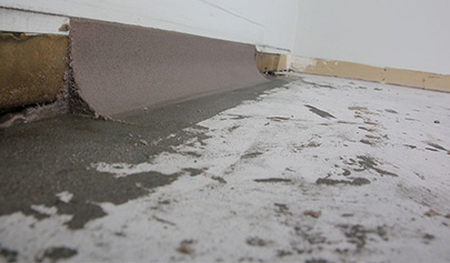 A close-up, low-angle shot showing an epoxy cove being installed.