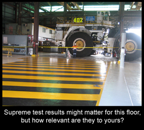 Resin floor in a mining workshop with large machinery on top.