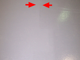 Arrows used on an image of a light grey floor to show a visible colour difference as the result of colour separation.