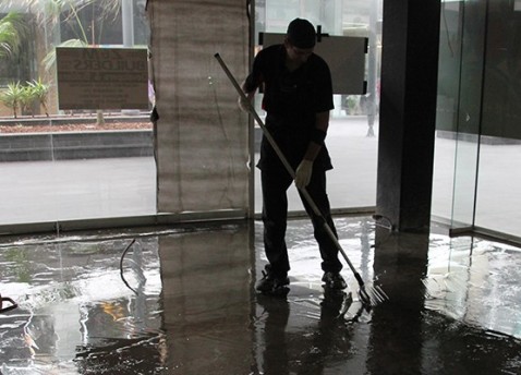 An installer using a squeegee to position a clear decorative epoxy resin.