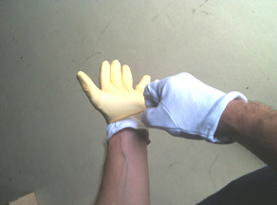 An installer putting on latex gloves over cotton inner gloves.