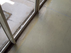 Yellowing of an indoor epoxy underneath the roller door line located inside sliding glass doors.