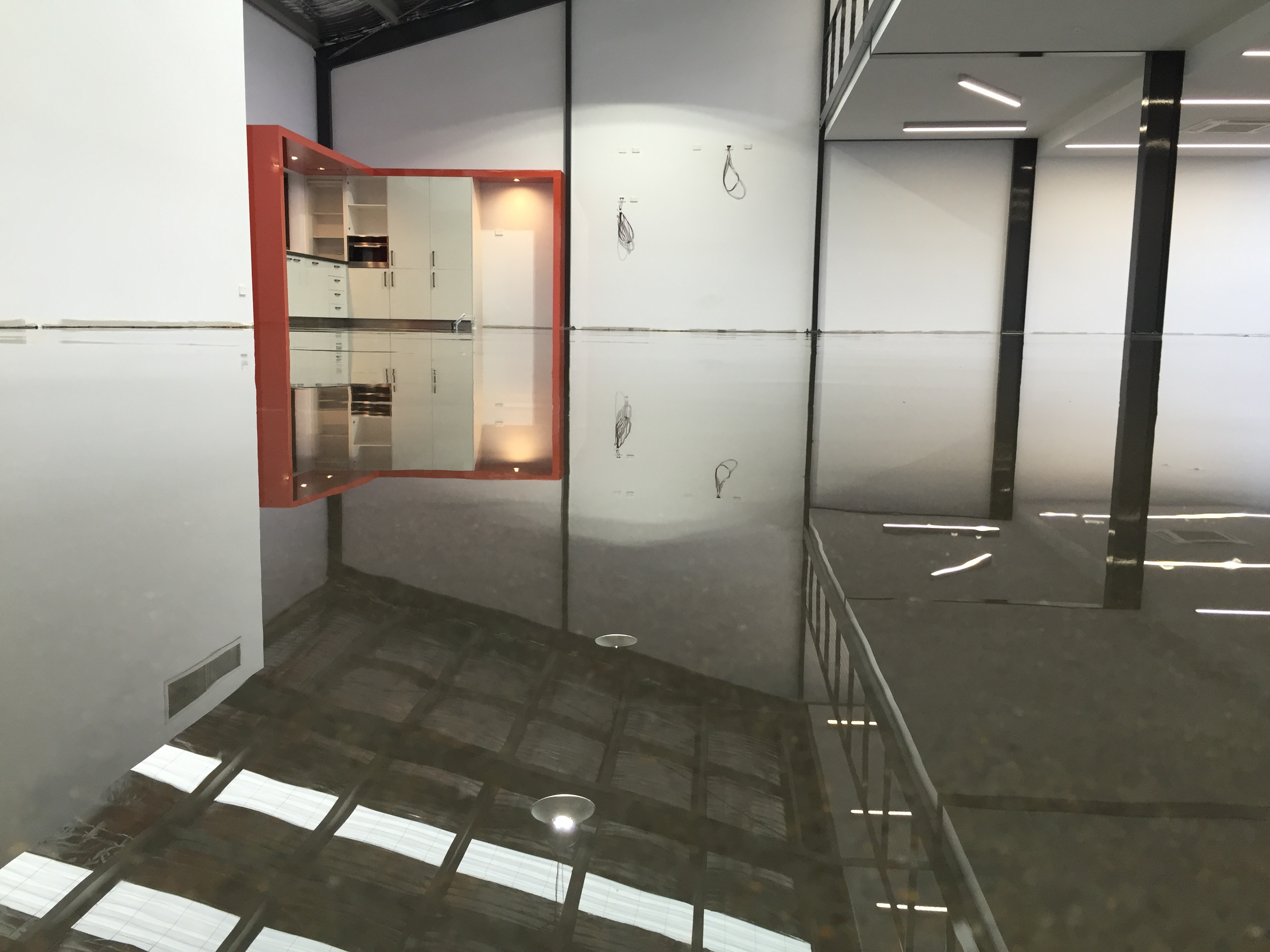 A clear epoxy resin used to create the polished concrete look in a modern open-plan apartment.