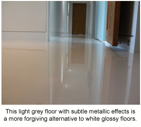 A low-angle photo of a glossy metallic floor in a residential hallway.