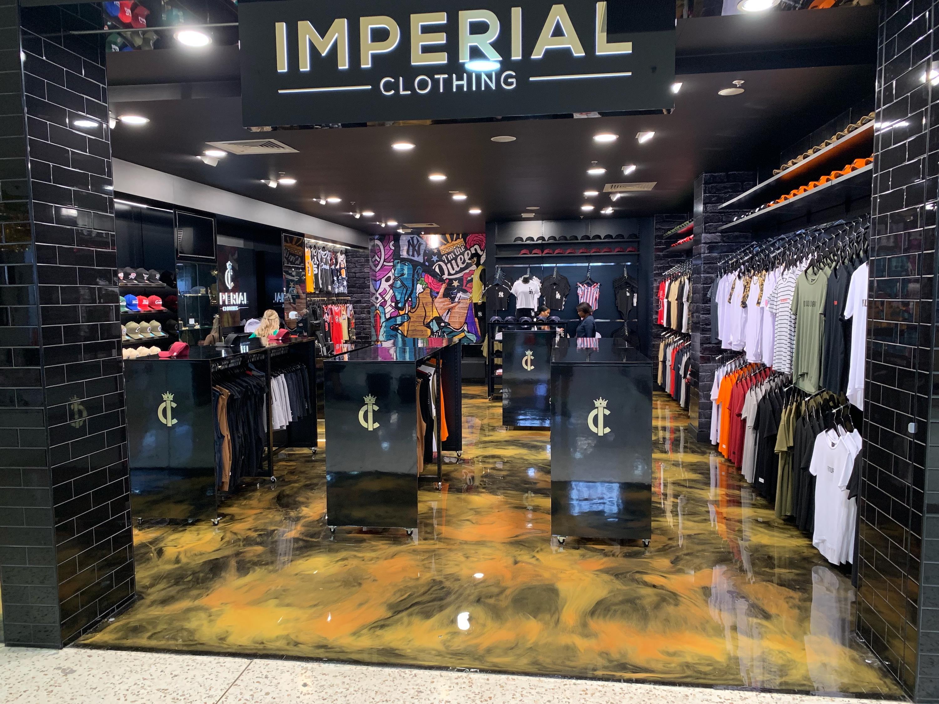 The entrance to a clothing retail store with a bold yellow and black decorative floor.