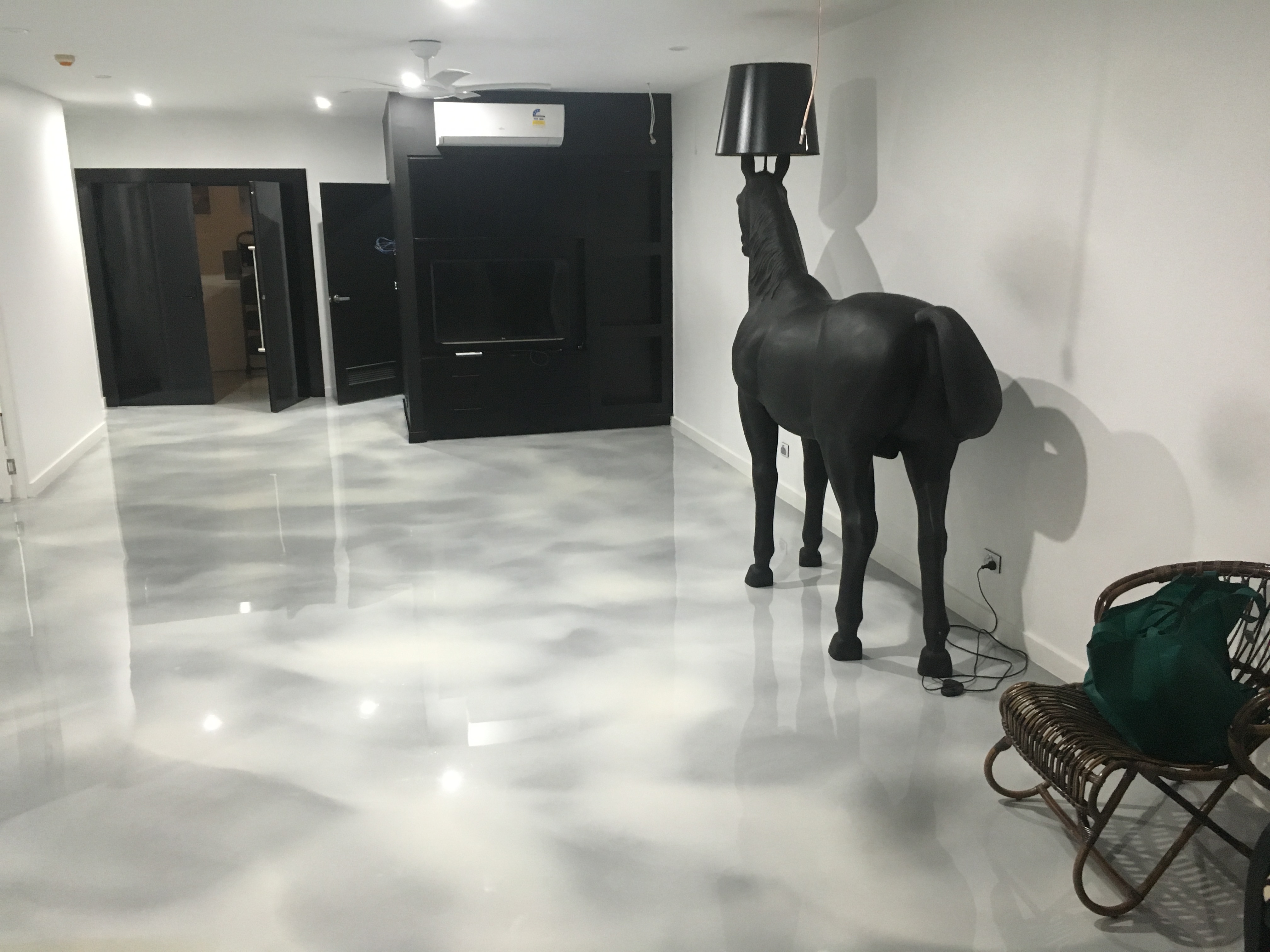A black horse statue standing on top of a stylish metallic decorative floor in a modern penthouse.