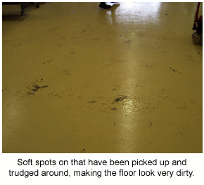 Soft spots on a factory floor appear that have darken due to dirt sticking to the tacky film.
