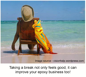 A person enjoying their holiday sitting on the beach in a deck chair.