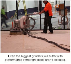 A contractor uses a large grinder to prepare a floor in a stadium bar.