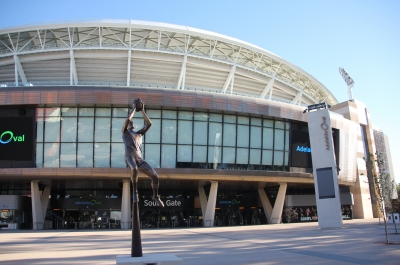 The outside concourse of the Adelaide Oval with statue of football player in foreground.