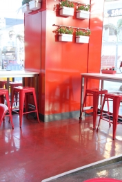 The front of the food outlet, with the vibrant red decorative epoxy floor complementing the decor perfectly.