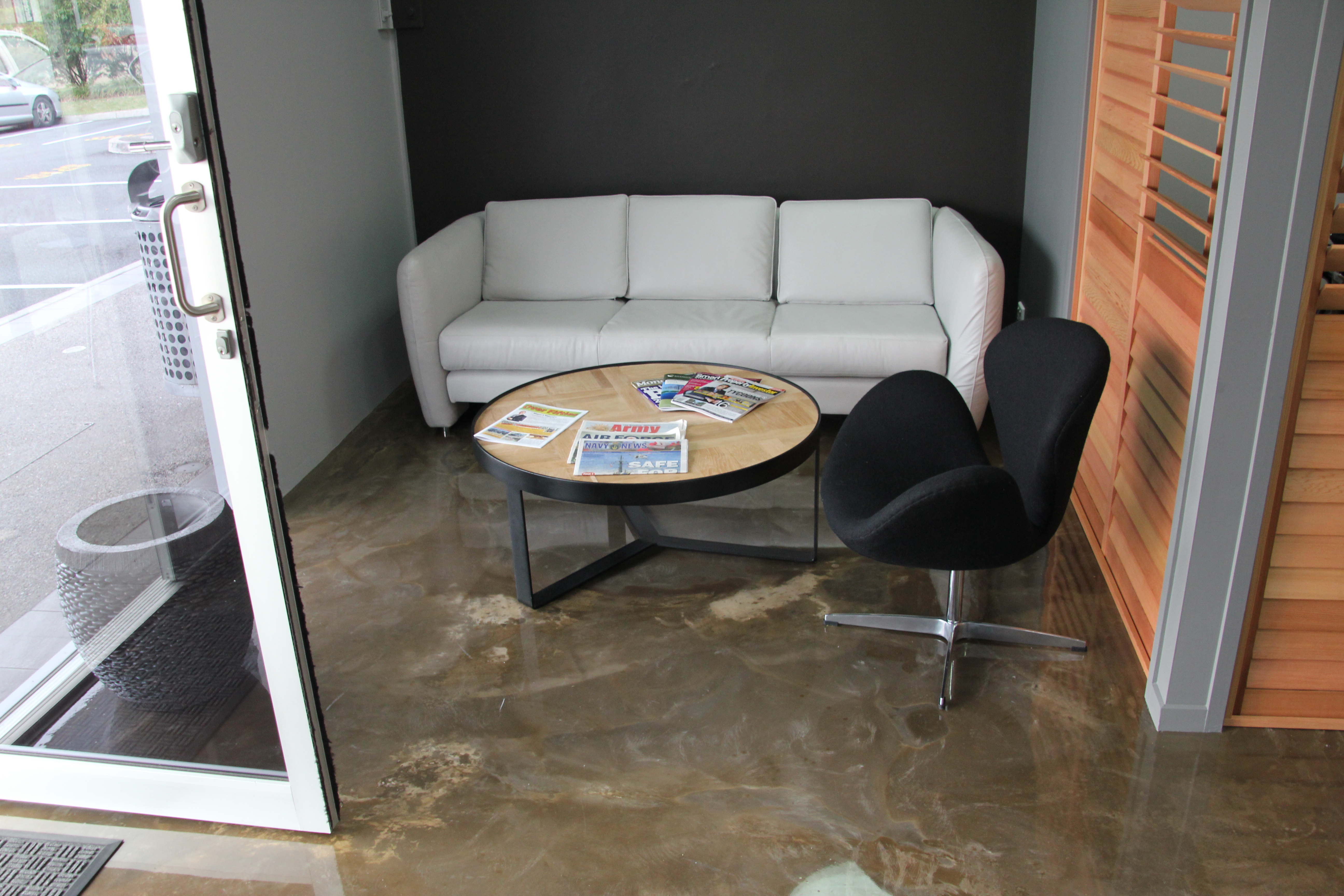 A high-gloss, stone-like decorative epoxy floor in the waiting room of the real estate office.
