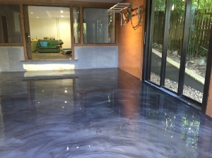 A decorative epoxy floor in a residential living room with stunning purple metallic effects.