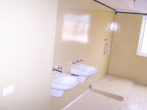 Industrial epoxy flooring and wall coating in a prison cell.