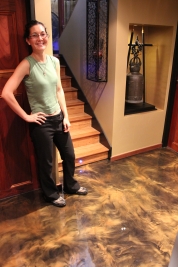 The happy homeowner standing on the gold metallic epoxy floor after the project had been completed.