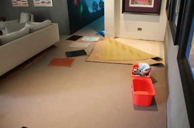 The living room area with part of the original, water-damaged carpet pulled up before the metallic epoxy floor was installed.
