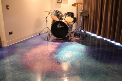 The cosmic-looking metallic epoxy floor worked beautifully with the games room, including this impressive drum kit.