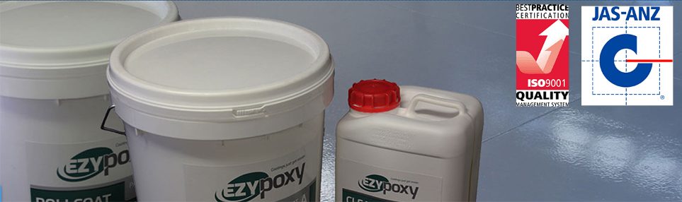 Two buckets and a drum of Real World Epoxies products sitting on a completed resin floor.