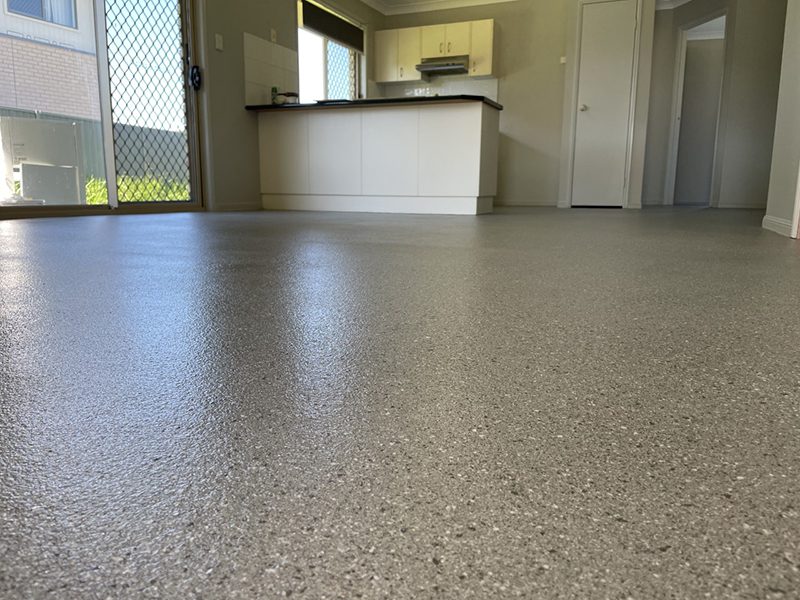 A low-angle shot of an epoxy flake floor with a modern granite look in a kitchen.