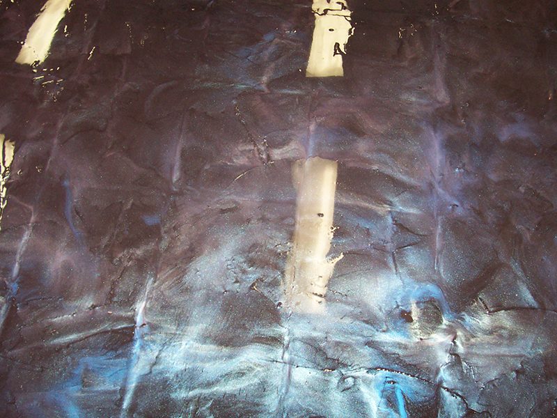 A metallic epoxy floor showing signs of ghosting from tiles underneath.