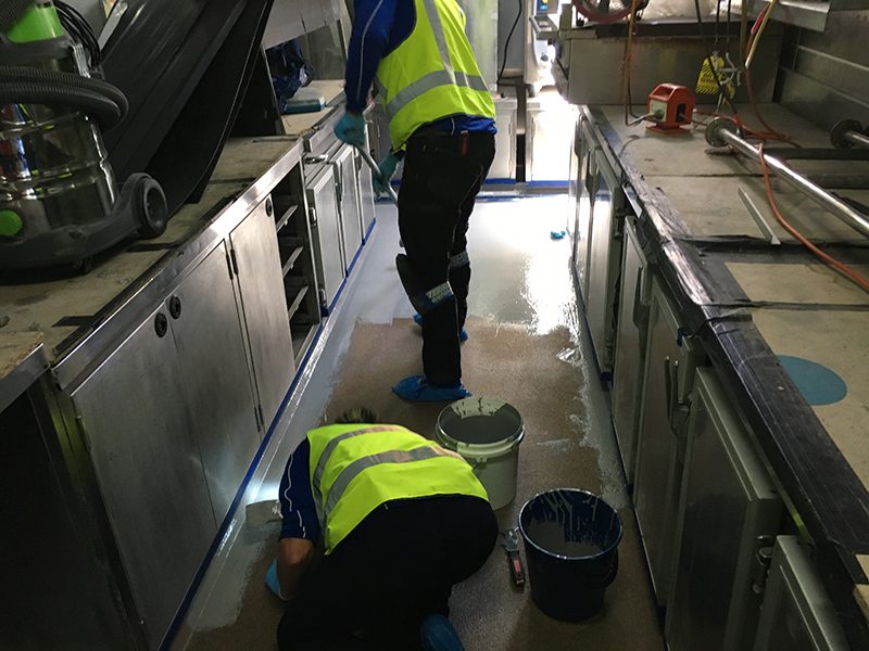 The application of non-slip epoxy coatings in a commercial kitchen.