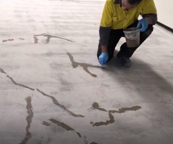 Patching cracks in concrete before the application of non-slip epoxy flooring.