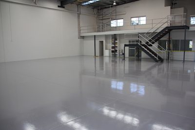 An empty warehouse showing a freshly applied coat of light grey Ezypoxy Rollcoat.