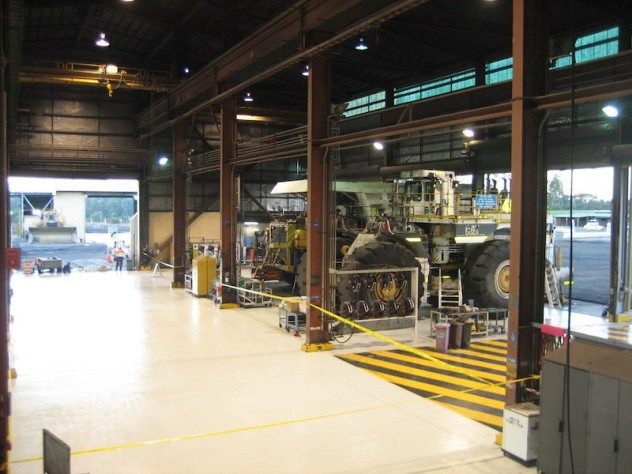 A mining workshop with heavy machinery parked on top of a floor system that used Jaxxon 1525.