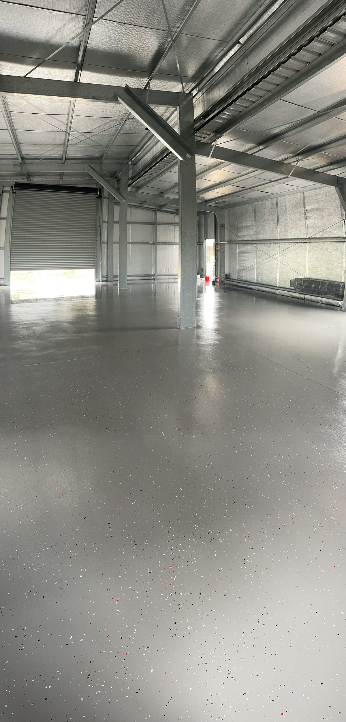 A low-angled shot of a partial flake floor in a warehouse that used pigmented and clear Ezypoly.