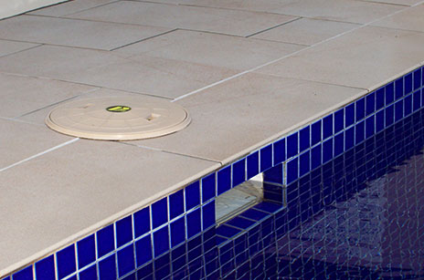The side of a swimming pool with tiles that had been repaired with Scubapoxy adhesive.