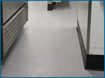 Seamless commercial epoxy flooring running throughout a commercial kitchen.