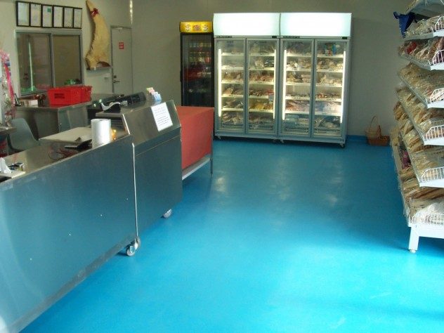 A light blue Resin Grip system installed for non-slip properties in the serving area of a fish marketplace.