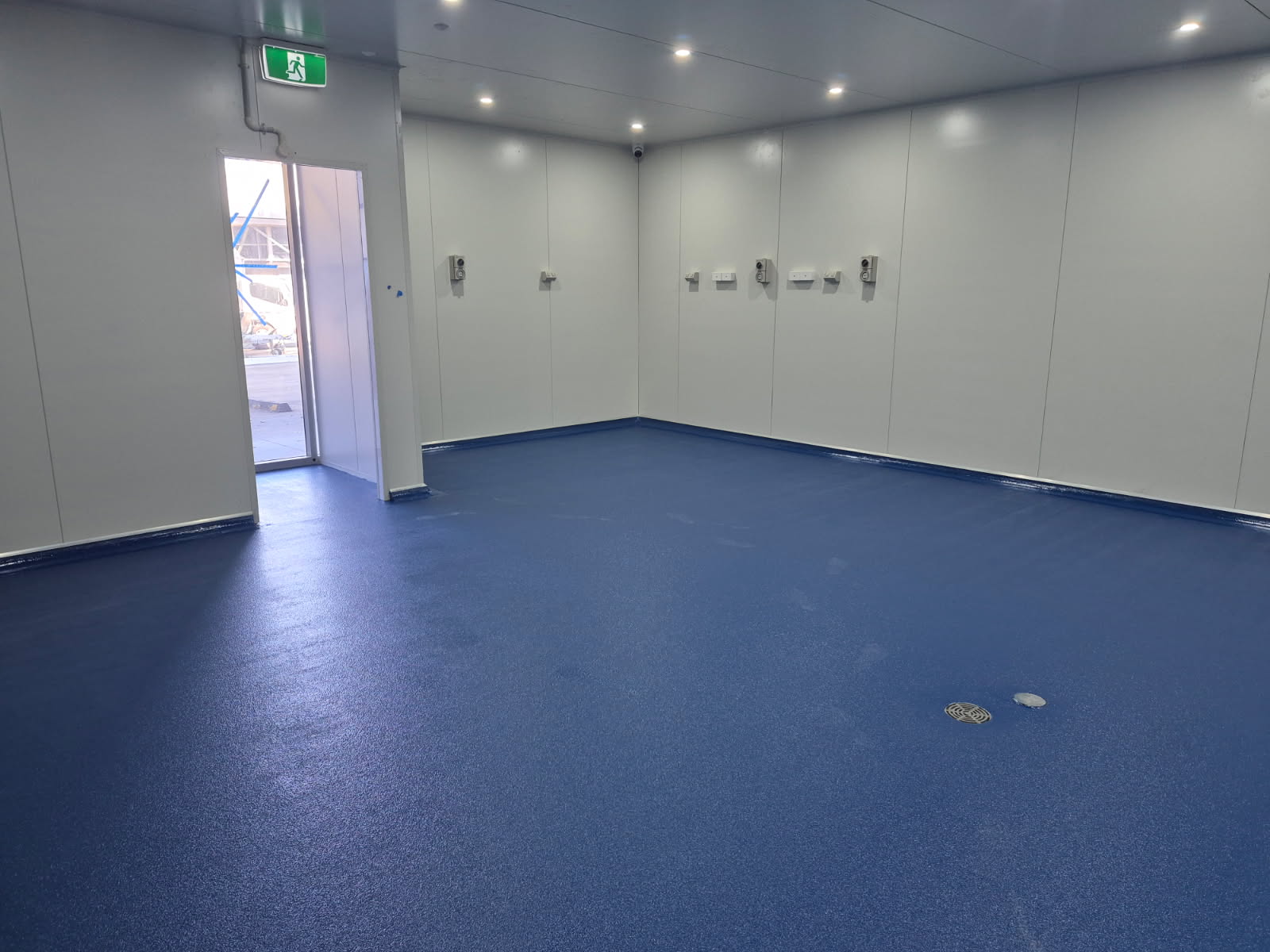 A low angle shot of the vibrant signal red non-slip epoxy floor showing the aggressive non-slip texture required in the abattoir.