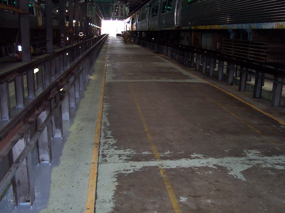 A photo taken before the project started showing the worn out floor coating that was previously in the workshop.