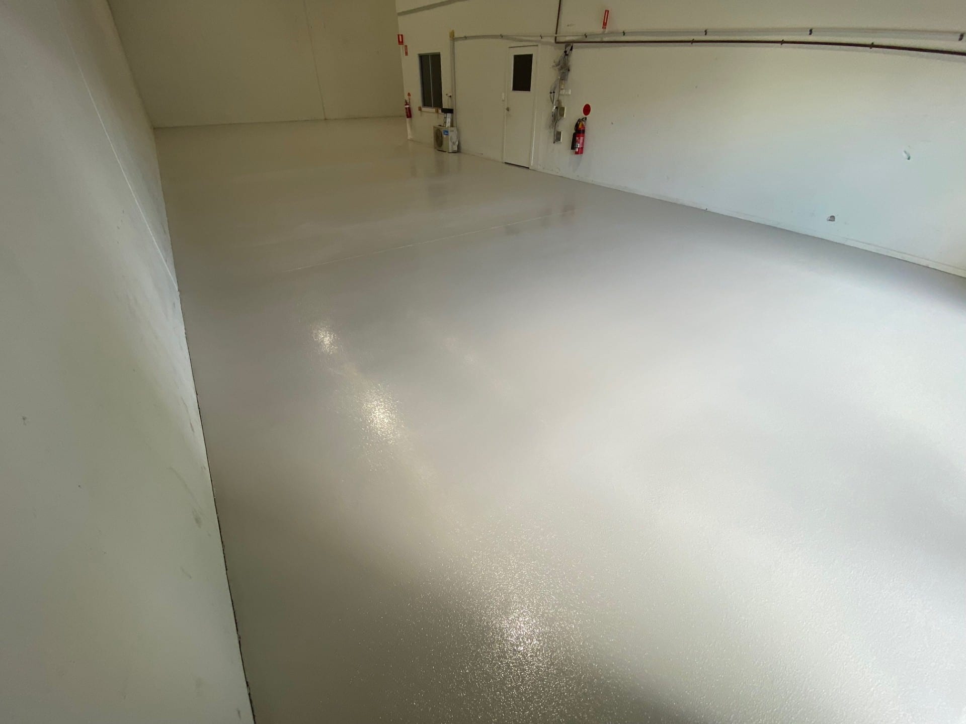 A low angle shot of the vibrant signal red non-slip epoxy floor showing the aggressive non-slip texture required in the abattoir.