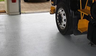 A fire truck parked on top of a Resin Grip system in a fire station with the texture of the non-slip finish visible.