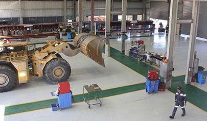 A large piece of mining machinery sitting on top of a Resin Grip system in a workshop.