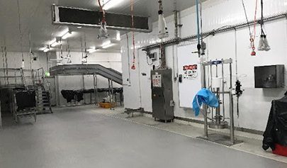 A Resin Rock system installed in a food processing facility with many pieces of machinery on the floor.