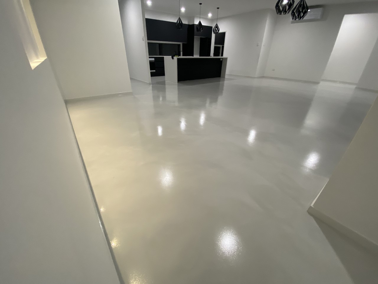 A residential epoxy flooring system from Real World Epoxies in the kitchen of a large, modern home.