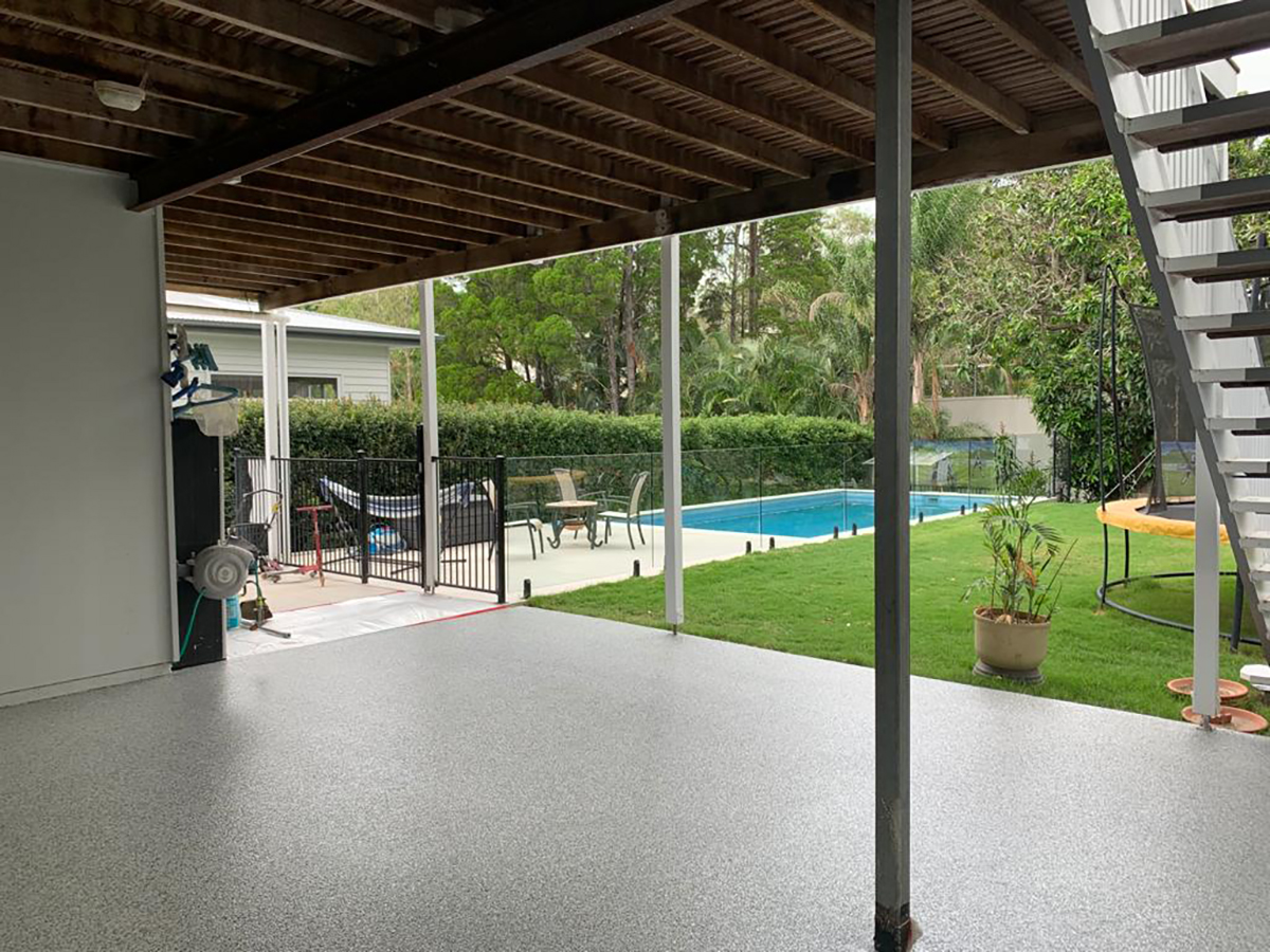A residential epoxy flooring system from Real World Epoxies in the backyard patio and outdoor area of a home.