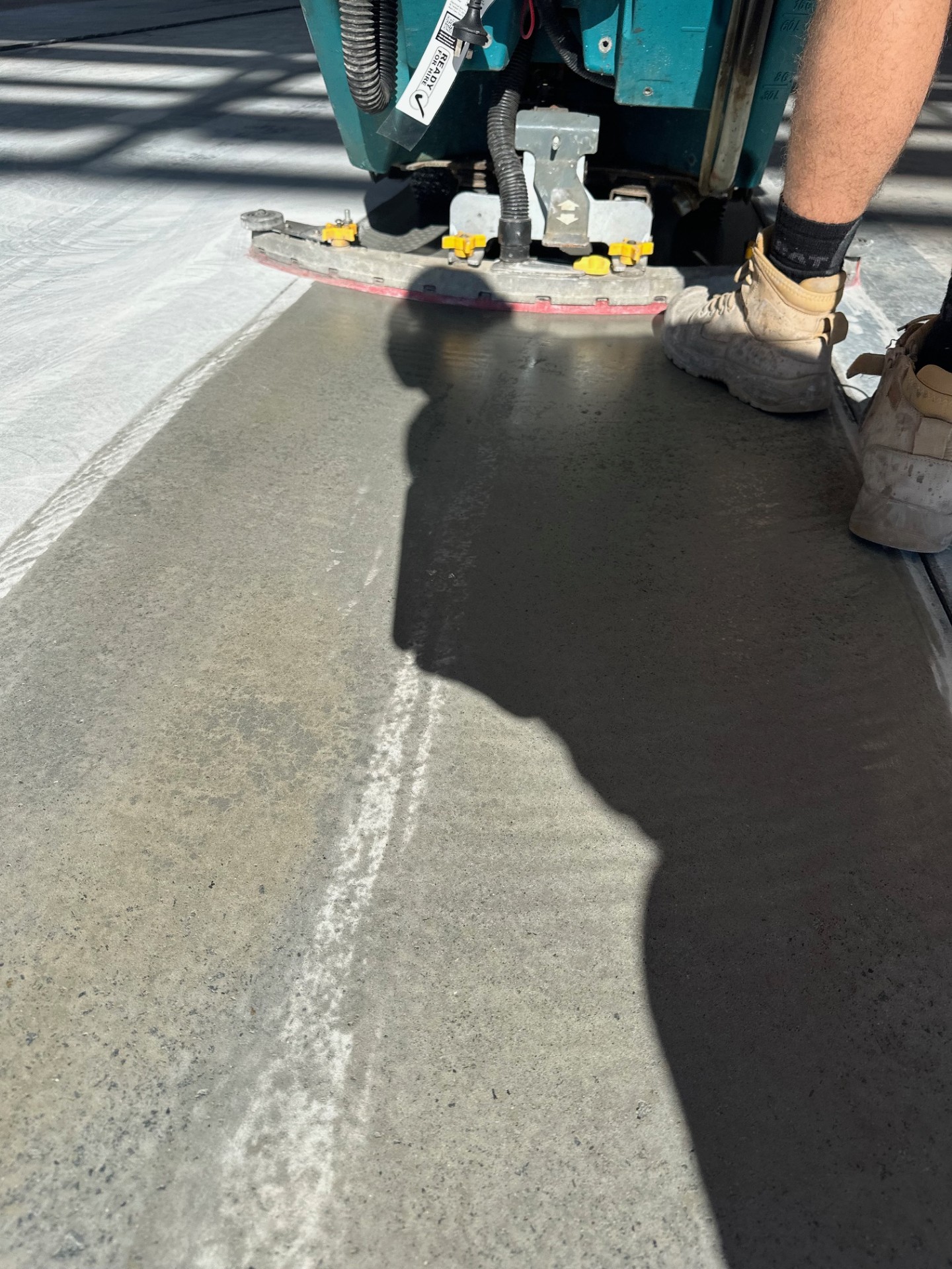 A view from inside the empty warehouse looking back towards the entrance with the new protective epoxy floor in the foreground.