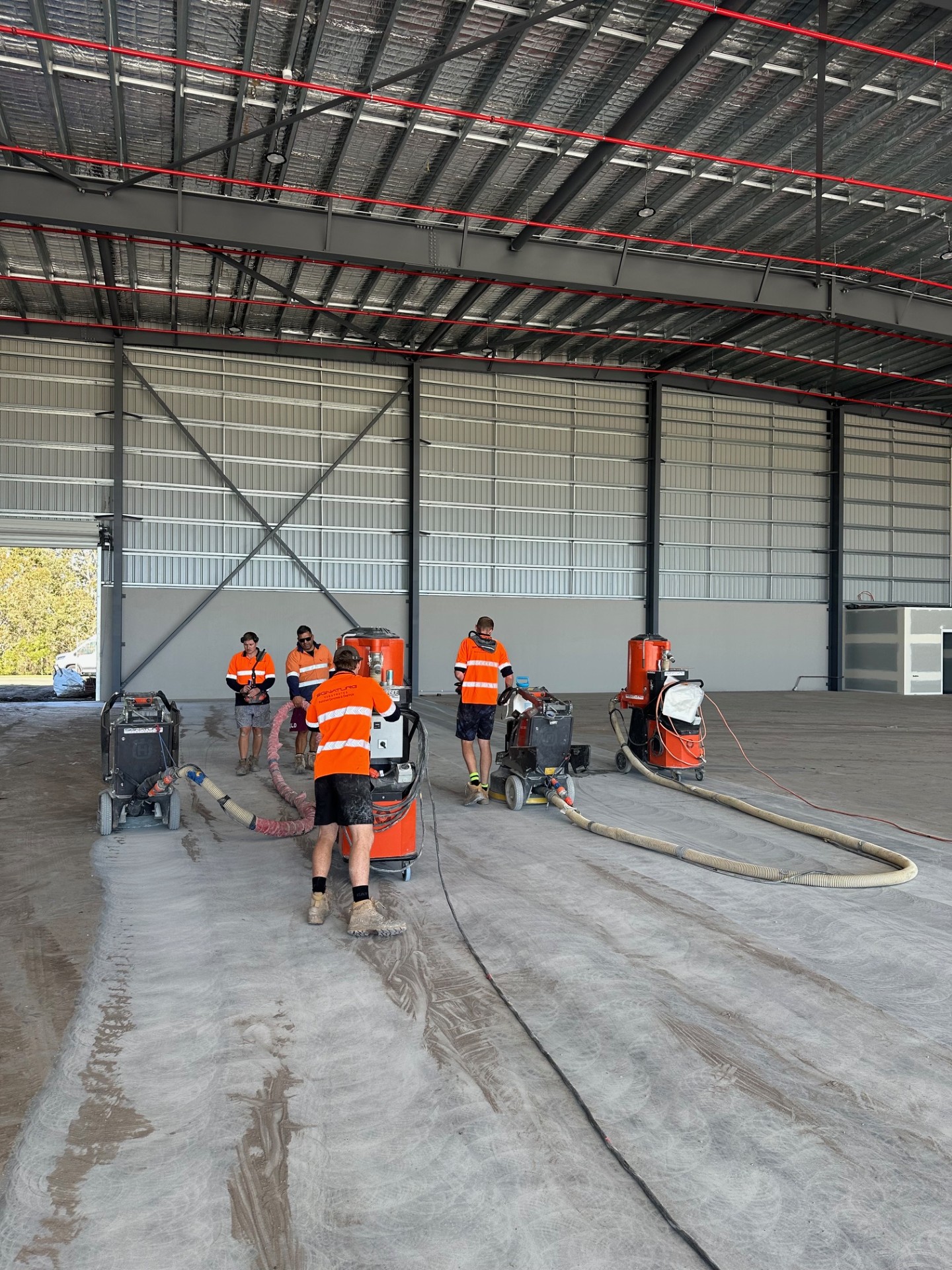 A view of the empty warehouse from the open front door showing the new protective epoxy floor covering the large area.