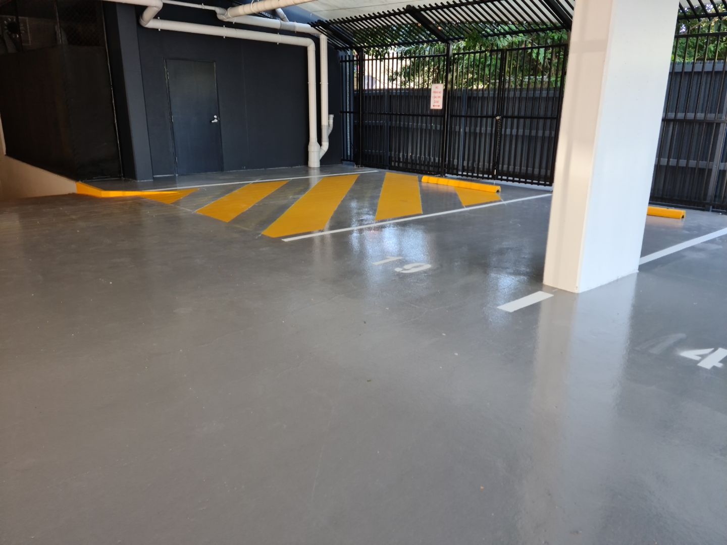 A view from inside the empty warehouse looking back towards the entrance with the new protective epoxy floor in the foreground.