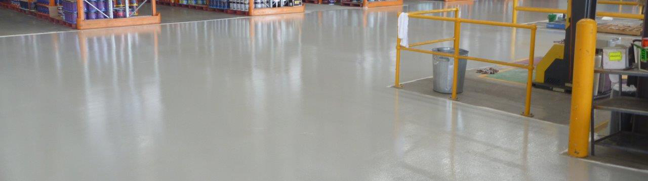 A photo showing a section of a light grey warehouse epoxy floor in service.