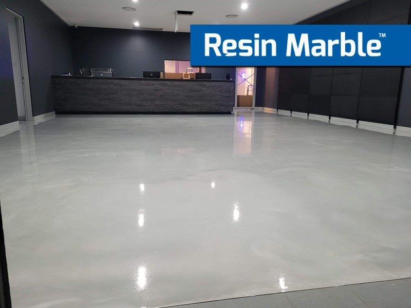 A low-angle photo of a Resin Marble floor in a commercial foyer showing the high-gloss finish of the metallic epoxy flooring system.
