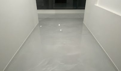 A close up of a high-gloss Resin Marble finish in a residential hallway with the reflection of the window and ceiling lights visible.
