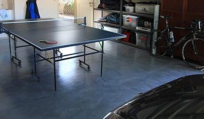 A table tennis table and racing bicycle sitting on top of a Resin Marble system installed in a domestic garage.