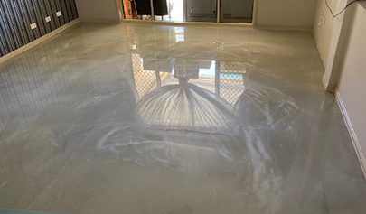 A close up of a high-gloss Oyster Resin Marble finish in a residential living room with the reflection of the window visible.